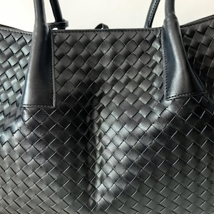 Front panel detail of black woven nappa leather tote bag with intrecciato weave