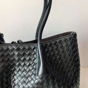 Black nappa leather woven tote bag side view with structured shoulder handles
