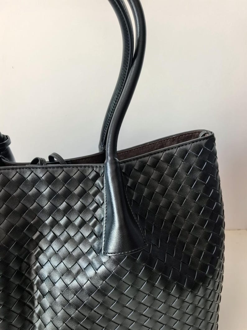 Black nappa leather woven tote bag side view with structured shoulder handles