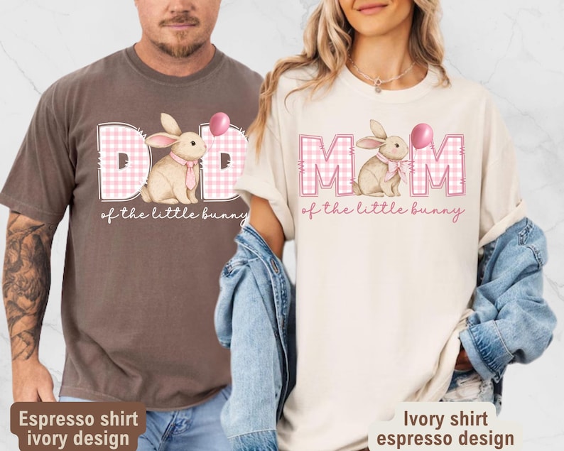 May include: Two t-shirts, one espresso and one ivory, feature a bunny graphic with the text "DAD of the little bunny" and "MOM of the little bunny". The bunny is wearing a pink bow tie and holding a pink balloon. The shirts are a casual style.