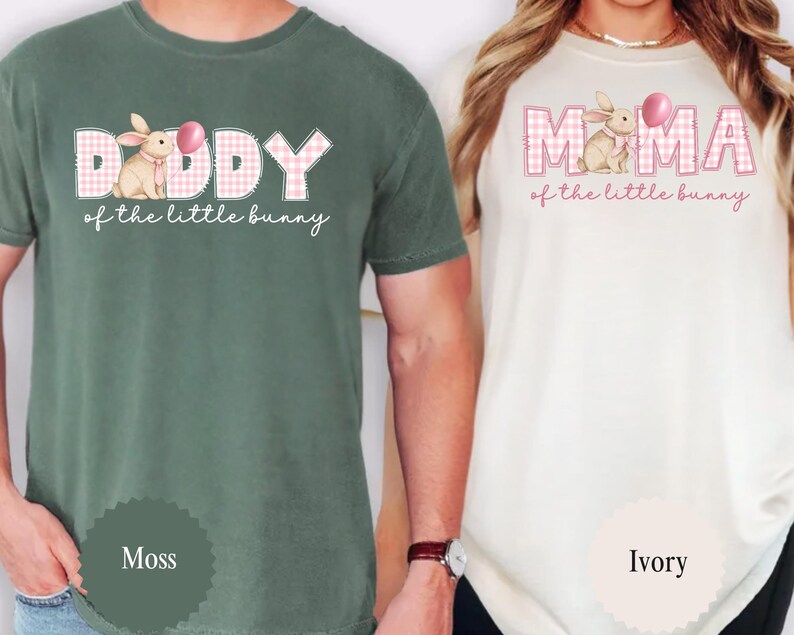 May include: Two t-shirts, one moss green and one ivory, featuring Easter-themed designs. The moss green shirt says "Daddy of the little bunny" with a bunny graphic. The ivory shirt says "Mama of the little bunny".