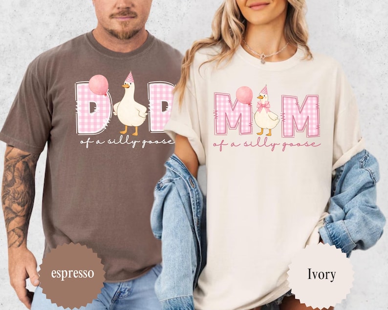 May include: Espresso and ivory-colored t-shirts with matching graphics. The shirts feature the words "DAD" and "MOM" in pink gingham, with a cartoon goose wearing a party hat and holding a balloon. The phrase "of a silly goose" is written below.