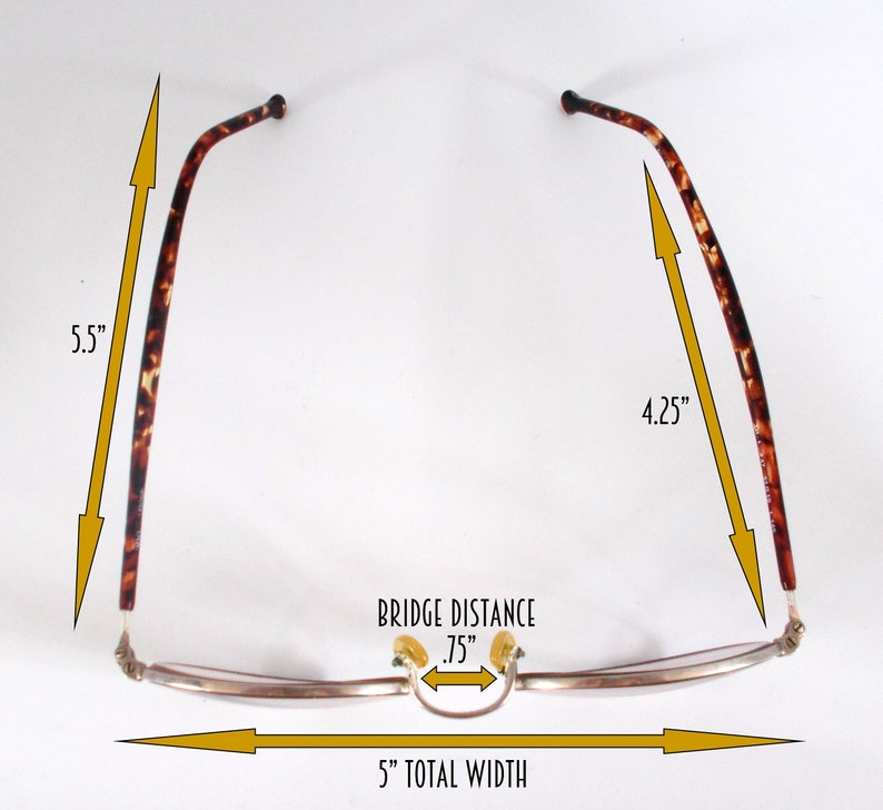 May include: Eyeglasses with a 5-inch total width, .75-inch bridge distance, and 5.5-inch and 4.25-inch temples. The frames are silver-toned with tortoise shell arms. The glasses have a classic, rectangular shape.