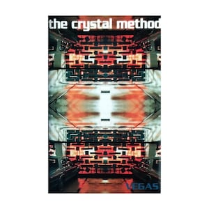 May include: Album cover for "The Crystal Method" featuring a mirrored, abstract design with red and black geometric shapes. The word "VEGAS" is in blue at the bottom. The title "the crystal method" is at the top.