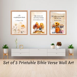 Puede incluir: Juego de 3 impresiones artísticas enmarcadas con versículos bíblicos. Las impresiones presentan ilustraciones en acuarela de flores, árboles y girasoles en tarros. El texto incluye "Dad gracias en todo", "Nuevas son cada mañana sus misericordias", y "El Señor es mi fortaleza y mi cántico."