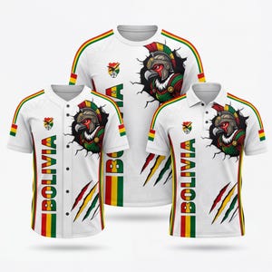 Puede incluir: Tres camisetas deportivas blancas con la palabra "BOLIVIA" en texto vertical. Cada camiseta presenta un gráfico de águila estilizado y los colores de la bandera boliviana. Una es una camiseta de béisbol, otra un polo y otra un cuello redondo.
