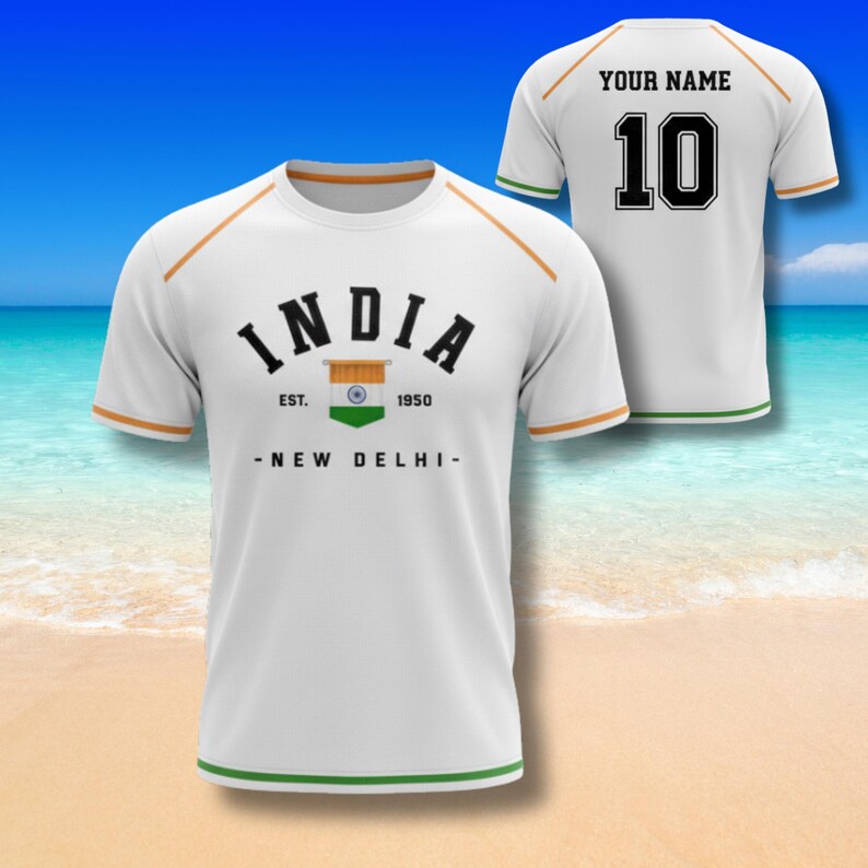 Pu&ograve; includere: Maglietta bianca con la scritta "INDIA" in nero, una grafica della bandiera indiana e la scritta "EST. 1950 - NEW DELHI-". La maglietta ha finiture arancioni e verdi. Il retro ha "YOUR NAME" e il numero "10".