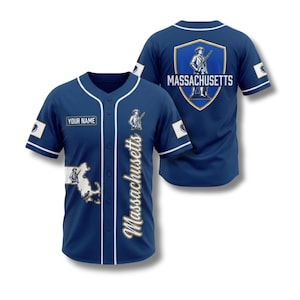 Könnte beinhalten: Ein marineblaues Baseball-Trikot mit weißen Akzenten, das den Schriftzug "Massachusetts" und eine Grafik eines Minuteman zeigt. Das Trikot hat ein "YOUR NAME"-Etikett und eine Schildgrafik auf dem Rücken.