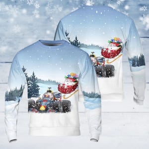 May include: A long-sleeved sweatshirt with a winter scene featuring a Formula 1 race car and Santa Claus in a sleigh. The design includes a snowy landscape with pine trees and a light blue sky. The sweatshirt is white.