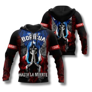 May include: Black hoodie with a design featuring the Puerto Rican flag, a skull, and the word "BORICUA". The sleeves have the word "NAME" and "YOUR" printed on them. The phrase "HASTA LA MUERTE" is printed on the bottom.