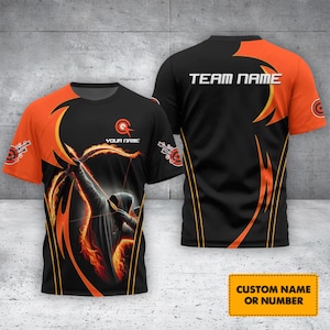 Peut inclure: T-shirt noir et orange à manches courtes avec un graphisme d'archer. Le t-shirt affiche le texte "YOUR NAME" et "TEAM NAME". Le bas du t-shirt porte l'inscription "CUSTOM NAME OR NUMBER".