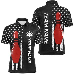 May include: Black polo shirt featuring a red bowling pin design with white stripes and star patterns. The shirt includes the text "YOUR NAME" and a bowling ball and pins graphic on the front, and "TEAM NAME" on the back.