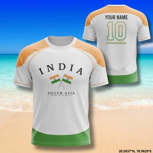 Pu&ograve; includere: Maglietta bianca con dettagli arancioni e verdi, con la scritta "INDIA" sopra bandiere incrociate. Il retro mostra "YOUR NAME" e il numero "10". Il design della maglietta incorpora i colori della bandiera indiana.