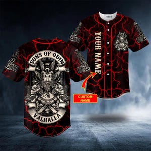 Puede incluir: Una camiseta de béisbol roja y negra con temática de mitología nórdica. La camiseta presenta un gráfico de Odín, el texto "Sons of Odin Valhalla" y un espacio para un nombre personalizado. El diseño incluye patrones de rayos.