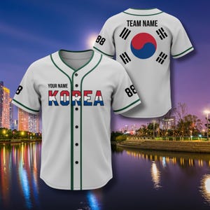 May include: White baseball jersey with green trim and the word "KOREA" in red, white, and blue lettering. The jersey has the number "88" on the sleeves and a Korean flag design on the back. The text "YOUR NAME" is above the word "KOREA".