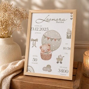 Könnte beinhalten: Ein gerahmter Druck mit dem Namen "Leonara" und Geburtsdetails. Es zeigt einen Teddybären in einem Heißluftballon mit den Maßen 50 cm Höhe und einem Gewicht von 3400 Gramm. Das Geburtsdatum ist der 23. Dezember 2025.
