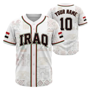 May include: White baseball jersey with "IRAQ" in black letters outlined in red and green. The jersey features the Iraqi flag on the sleeves and a design with Iraqi cultural elements. The back has the number 10 and space for a name.