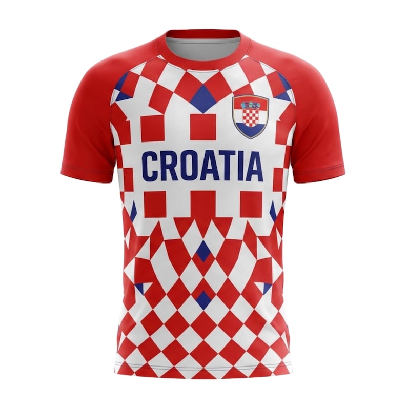 Pu&ograve; includere: Una maglia da calcio della Croazia a scacchi rossi e bianchi con maniche rosse. La maglia presenta la scritta "CROAZIA" in lettere blu sul petto e uno stemma con lo stemma croato.