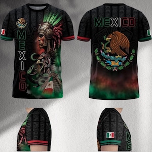 Puede incluir: Camiseta negra con un gráfico detallado de un jefe nativo americano, un águila y una serpiente, con la palabra "MEXICO" verticalmente en la parte delantera. La parte trasera presenta el escudo de armas mexicano y la palabra "MEXICO". Acentos rojos y verdes.