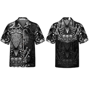 May include: A short-sleeve button-down shirt featuring a black and white graphic print of a bearded figure in a wide-brimmed hat holding a staff, surrounded by snarling wolf-like creatures, human skulls, and crossed swords in a detailed illustration.
