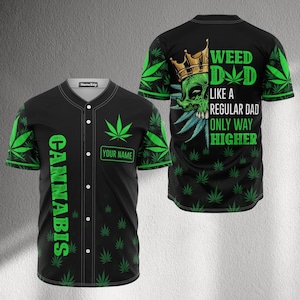 May include: Black baseball jersey with green cannabis leaf accents and the word "CANNABIS" in green. The back features a green skull wearing a gold crown with the text "WEED DAD LIKE A REGULAR DAD ONLY WAY HIGHER."