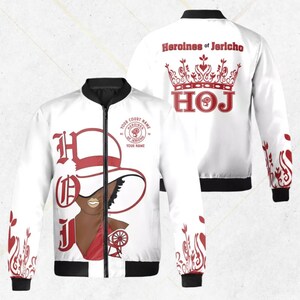 May include: White bomber jacket with black trim and a full-zip closure. The jacket features a red and white graphic of a woman wearing a hat, with the text "HOJ" and "Heroines of Jericho". The back of the jacket has a crown graphic and the text "Heroines of Jericho".