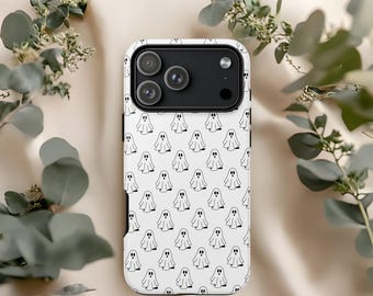 May include: White phone case with a repeating pattern of small, black ghost illustrations. The case has a black camera module and is surrounded by green foliage against a cream background. The case is designed to fit a smartphone.