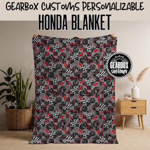 Op de afbeelding: Grijze Honda-deken met een herhaald patroon van rode en zwarte motorfietsen, helmen en geblokte vlaggen. De tekst "HONDA BLANKET" staat in grote zwarte letters. Het Gearbox Customs-logo staat in de hoek.