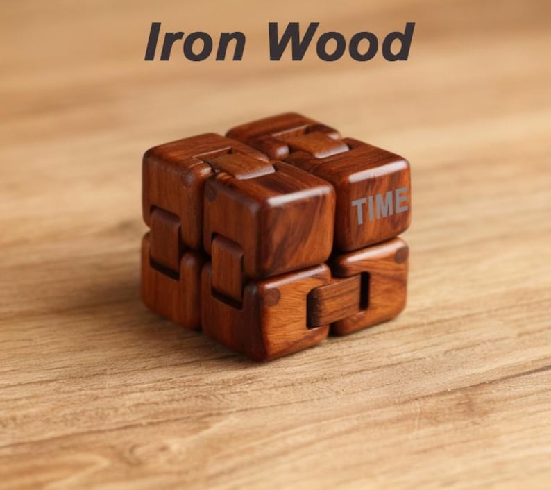 Puede incluir: Un cubo infinito de madera con la palabra "TIME" en un lado. El cubo es de madera marr&oacute;n oscuro y est&aacute; sobre una superficie de madera. El texto "Iron Wood" est&aacute; encima del cubo.