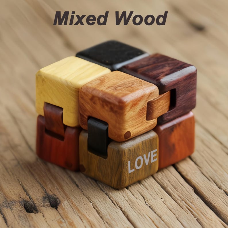 Puede incluir: Un rompecabezas de cubo de madera con varios tonos, incluyendo amarillo claro, marr&oacute;n oscuro y marr&oacute;n rojizo. La palabra "LOVE" est&aacute; impresa en una de las caras del cubo. El texto "Mixed Wood" est&aacute; en la parte superior de la imagen.