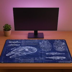 Może przedstawiać: Niebieska podkładka pod mysz z białymi schematami Millennium Falcon. Projekt zawiera wiele widoków statku ze szczegółowymi rysunkami technicznymi. Monitor komputera i mała roślina doniczkowa znajdują się w tle.