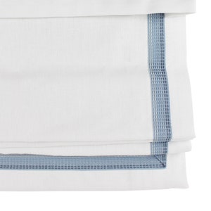 May include: White fabric with a blue embroidered border. The fabric is folded in thirds, showing the border on each fold.
