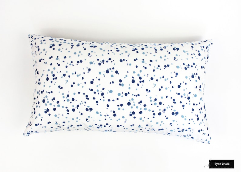 May include: A white cushion with a blue and light blue polka dot pattern.