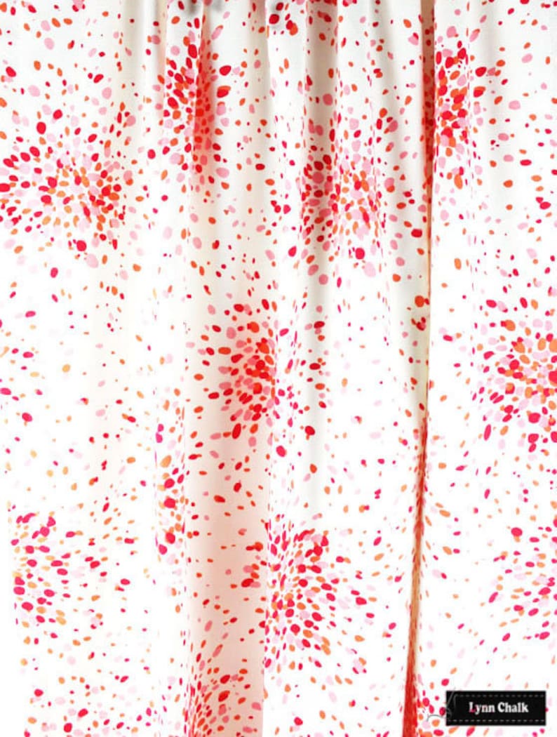 May include: White fabric with a red and pink confetti pattern. The fabric has a subtle sheen and is ideal for crafting or sewing projects.
