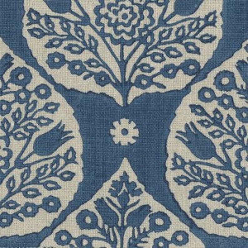 Op de afbeelding: Blauwe en witte bloemenstof met een herhalend patroon van gestileerde bloemen en bladeren. De stof heeft een linnen textuur.