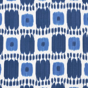 May include: A white fabric with a blue and white ikat pattern. The pattern is made up of repeating squares with a small circle in the center.