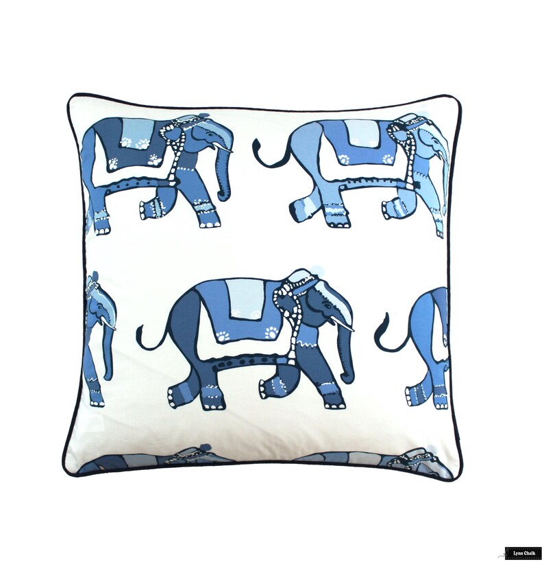 Puede incluir: Una almohada blanca con un borde negro presenta un patr&oacute;n repetido de elefantes azules. Los elefantes est&aacute;n estilizados y tienen un dise&ntilde;o indio tradicional.