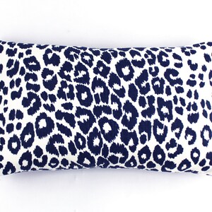 May include: A white rectangular pillow with a navy blue leopard print pattern.