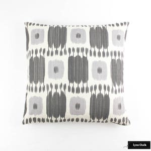 May include: A rectangular throw pillow with a white background and a geometric pattern in shades of gray and light purple.