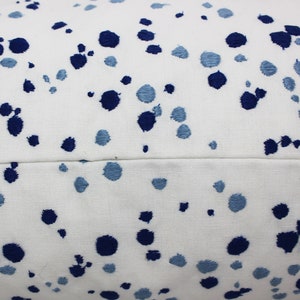 Op de afbeelding: Wit kussen met een blauw en lichtblauw gevlekt patroon.