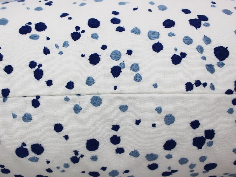 Op de afbeelding: Wit kussen met een blauw en lichtblauw gevlekt patroon.