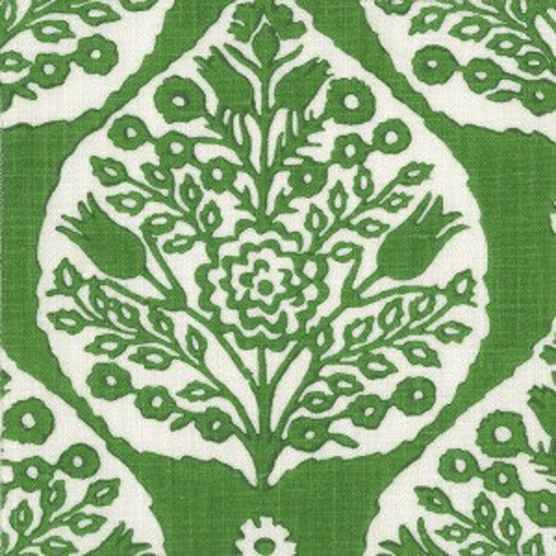 Op de afbeelding: Groene en witte stof met een herhalend patroon van gestileerde bloemenmotieven. Het patroon heeft een centrale bloem met twee gestileerde tulpen aan weerszijden, omringd door kleinere bladeren en bloemen.
