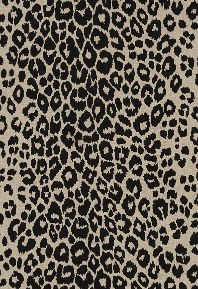 May include: A seamless pattern of black leopard spots on a beige background. The spots are irregular in shape and size, creating a dynamic and textured look.