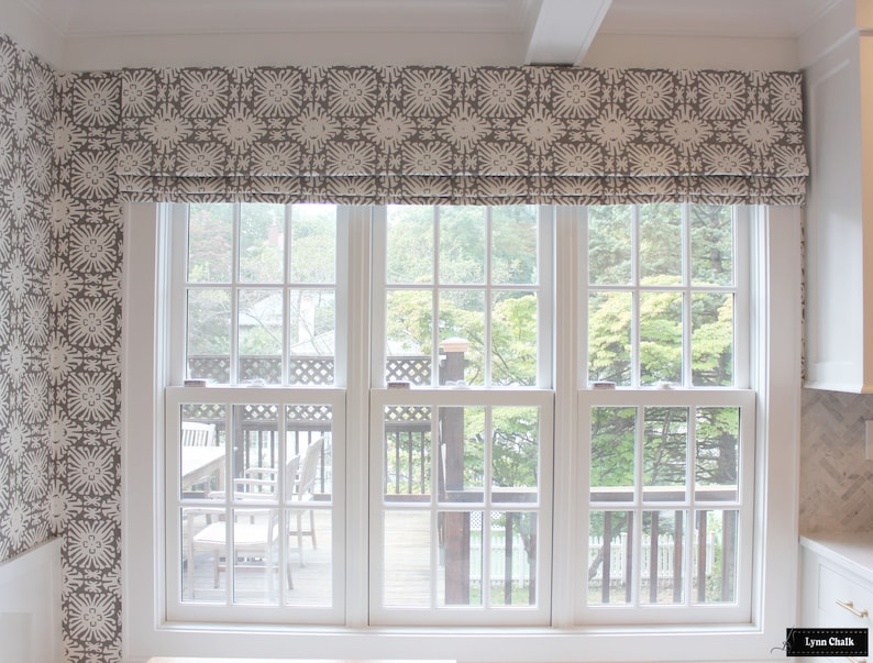 Puede incluir: Una ventana con marco blanco y una cenefa estampada. La cenefa tiene un dise&ntilde;o floral repetido en tonos grises y blancos. La ventana da a una terraza y &aacute;rboles.