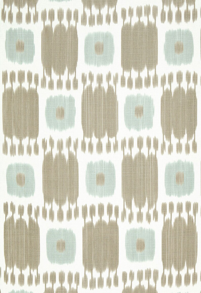 May include: A white fabric with a repeating pattern of brown and light blue geometric shapes. The pattern resembles an ikat design.