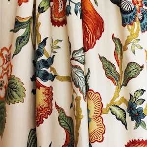 May include: White curtains with a floral pattern in shades of orange, red, green, and blue. The curtains have a traditional, vintage style.