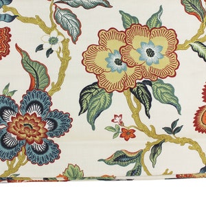 May include: A white fabric with a floral pattern featuring orange, red, yellow, blue, and green flowers. The fabric has a subtle sheen and a soft texture.