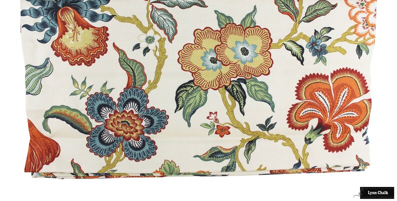 May include: A white fabric with a floral pattern featuring orange, red, yellow, blue, and green flowers. The fabric has a subtle sheen and a soft texture.