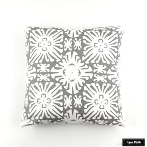 Puede incluir: Coj&iacute;n decorativo cuadrado con un patr&oacute;n geom&eacute;trico gris y blanco. El coj&iacute;n presenta un dise&ntilde;o floral repetido en blanco sobre un fondo gris. El coj&iacute;n es cuadrado y parece estar hecho de tela.