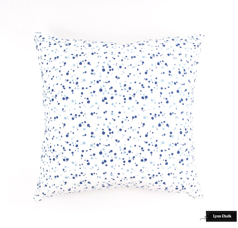 May include: A white square cushion with a blue and light blue confetti pattern.